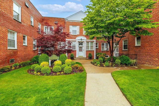 70 S Park Ave Unit 114, Rockville Centre, NY 11570 - view of front facade with brick siding and a front yard