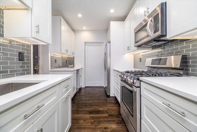 70 S Park Ave Unit 114, Rockville Centre, NY 11570 - kitchen featuring stainless steel appliances, tasteful backsplash, dark wood-style flooring, recessed lighting, and light countertops