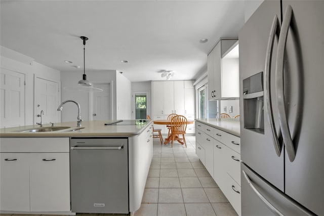 2 Driftwood Dr, Port Washington, NY 11050 - kitchen featuring appliances with stainless steel finishes, a sink, white cabinets, light tile patterned floors, and light countertops