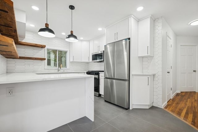 50 Christabel St, Lynbrook, NY 11563 - kitchen featuring appliances with stainless steel finishes, a peninsula, light countertops, white cabinetry, and recessed lighting