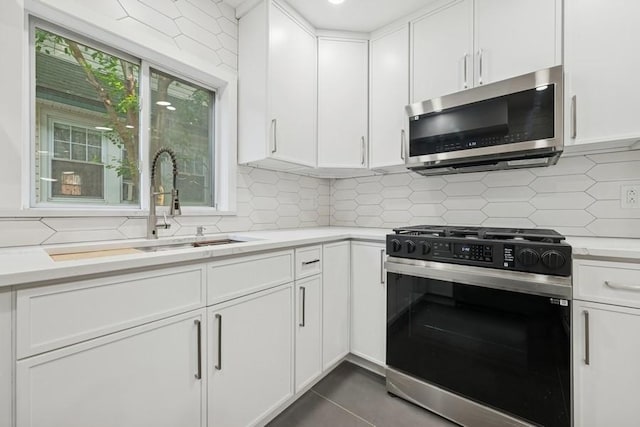 50 Christabel St, Lynbrook, NY 11563 - kitchen featuring stainless steel appliances, light countertops, backsplash, and white cabinets