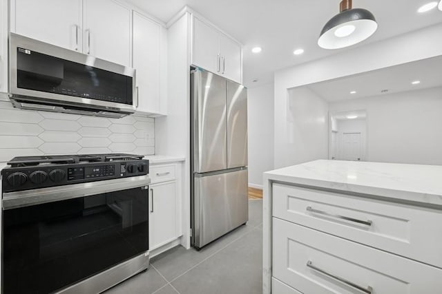 50 Christabel St, Lynbrook, NY 11563 - kitchen with stainless steel appliances, white cabinets, decorative backsplash, light stone counters, and recessed lighting