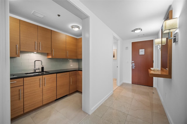 1 Renaissance Sq Unit 10B, White Plains, NY 10601 - kitchen with a sink, baseboards, brown cabinets, and dark countertops