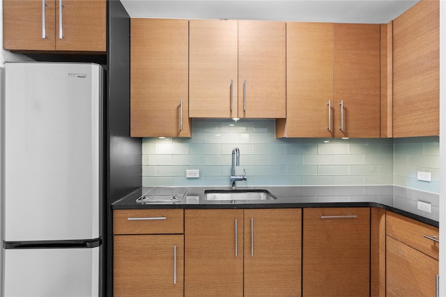 1 Renaissance Sq Unit 10B, White Plains, NY 10601 - kitchen featuring freestanding refrigerator, a sink, and tasteful backsplash