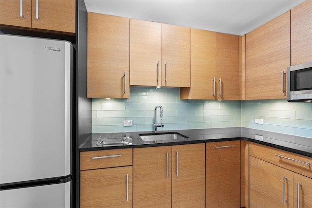 1 Renaissance Sq Unit 10B, White Plains, NY 10601 - kitchen featuring appliances with stainless steel finishes, a sink, decorative backsplash, and dark stone countertops