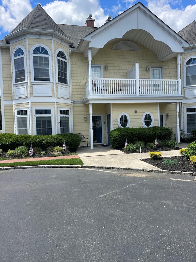 802 Emily Dr, Patchogue, NY 11772 - view of front of property with a chimney, a balcony, and a shingled roof
