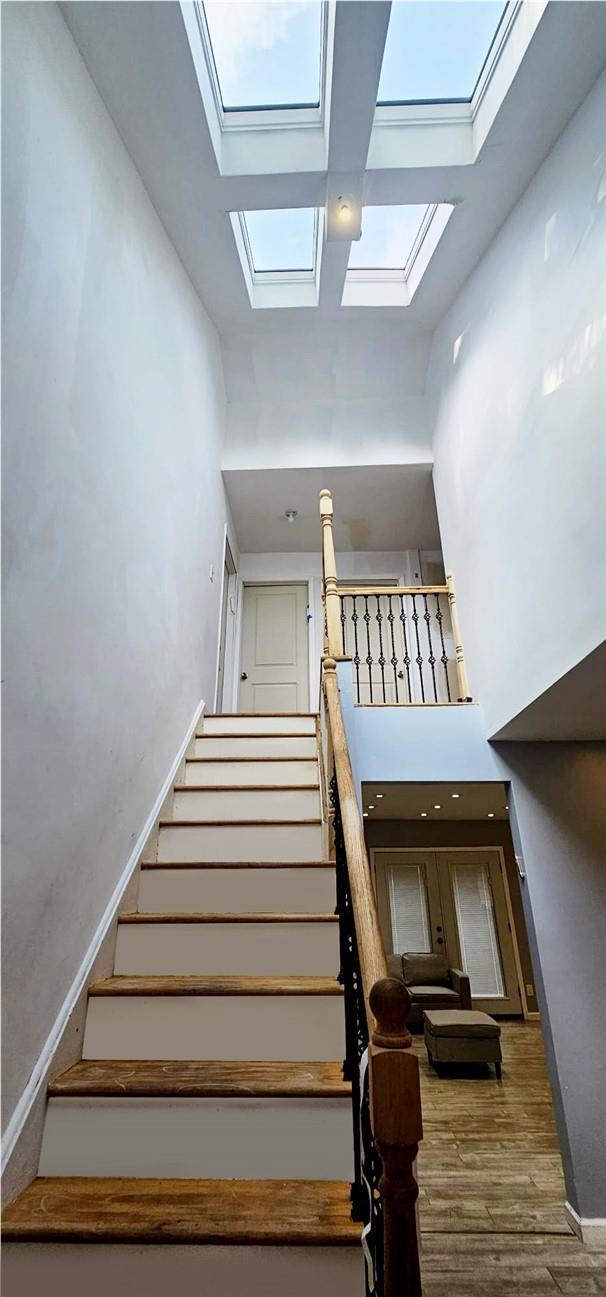 37 Starr Ave, Monticello, NY 12701 - stairway featuring a skylight, a towering ceiling, and wood finished floors