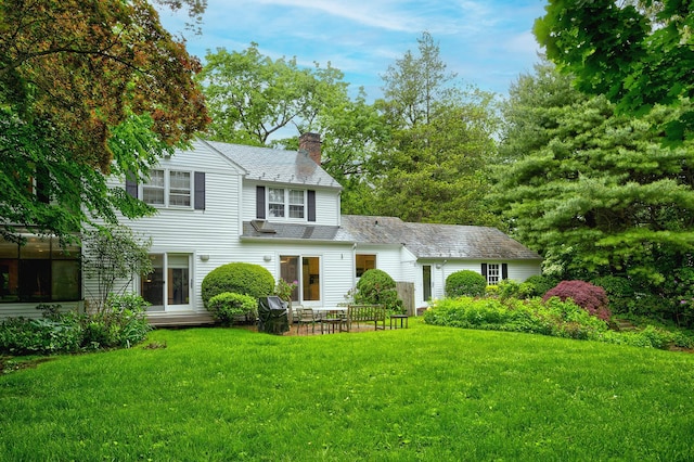 24 Cedar Ln, Sands Point, NY 11050 - view of front of property with a chimney, a front lawn, and a patio area