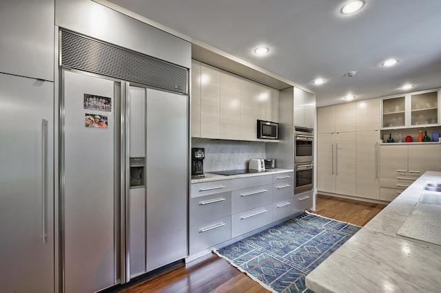 24 Cedar Ln, Sands Point, NY 11050 - kitchen featuring appliances with stainless steel finishes, modern cabinets, dark wood finished floors, recessed lighting, and tasteful backsplash