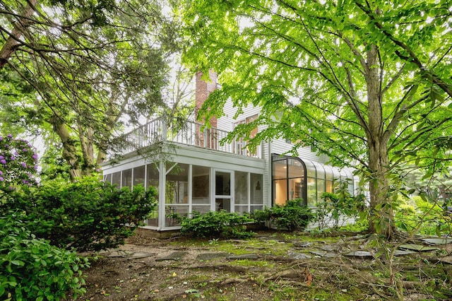 24 Cedar Ln, Sands Point, NY 11050 - rear view of property with a sunroom, a balcony, and a chimney