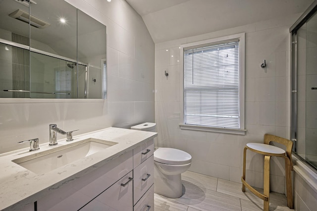 24 Cedar Ln, Sands Point, NY 11050 - full bathroom featuring tile walls, a shower with door, vanity, lofted ceiling, and toilet