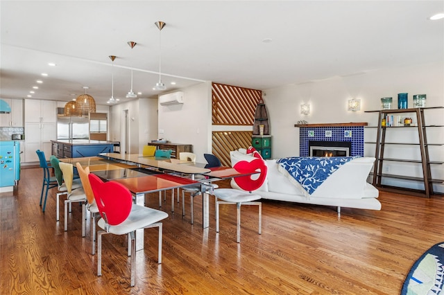 931A Oceanfront St, Long Beach, NY 11561 - dining area with a wall mounted air conditioner, wood finished floors, recessed lighting, a fireplace, and a baseboard heating unit