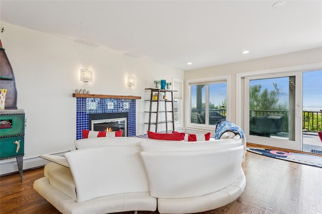 931A Oceanfront St, Long Beach, NY 11561 - living area with wood finished floors, a tiled fireplace, recessed lighting, and a baseboard radiator