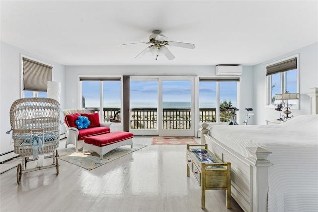 931A Oceanfront St, Long Beach, NY 11561 - bedroom with a wall mounted AC, access to outside, wood finished floors, a water view, and baseboard heating
