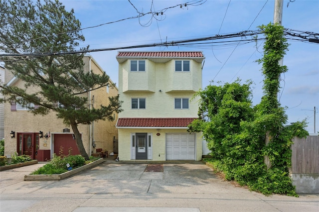 931A Oceanfront St, Long Beach, NY 11561 - view of front facade featuring a tiled roof, stucco siding, concrete driveway, and a garage