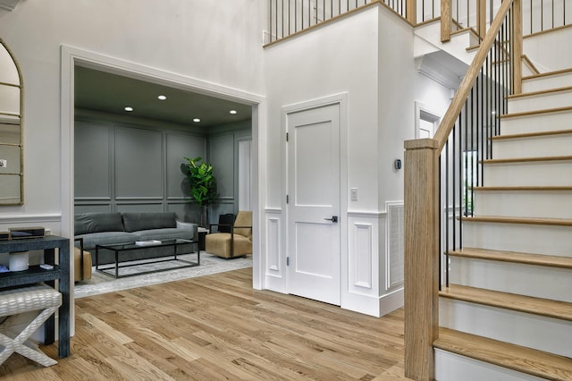 9 Wyndham Way, Port Washington, NY 11050 - stairway with a decorative wall, a towering ceiling, and wood finished floors