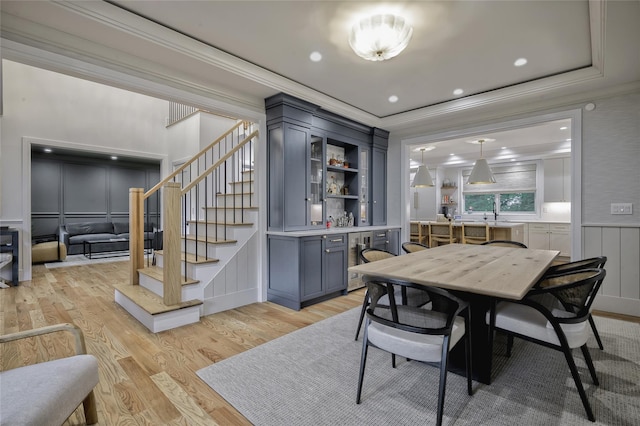 9 Wyndham Way, Port Washington, NY 11050 - dining area featuring ornamental molding, a decorative wall, light wood-type flooring, stairway, and a bar