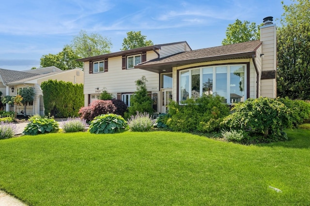 2432 Cadillac Dr, East Meadow, NY 11554 - tri-level home featuring a front yard and a chimney