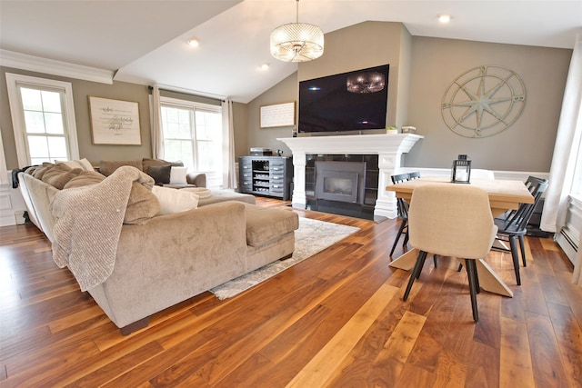 213 Glenwood Ln, Port Jefferson, NY 11777 - living area with a fireplace, wood finished floors, vaulted ceiling, and crown molding
