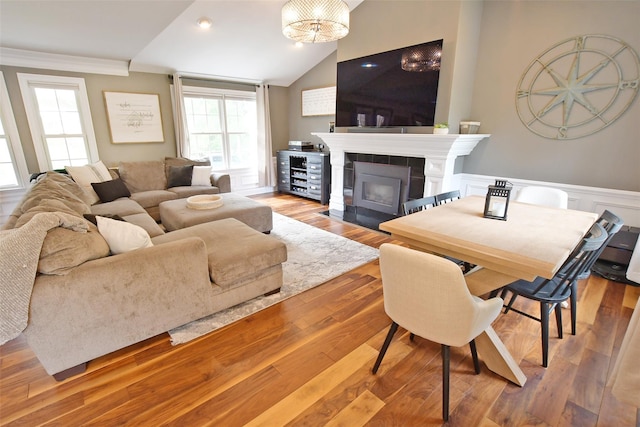 213 Glenwood Ln, Port Jefferson, NY 11777 - living area with a wainscoted wall, a tiled fireplace, lofted ceiling, crown molding, and wood finished floors
