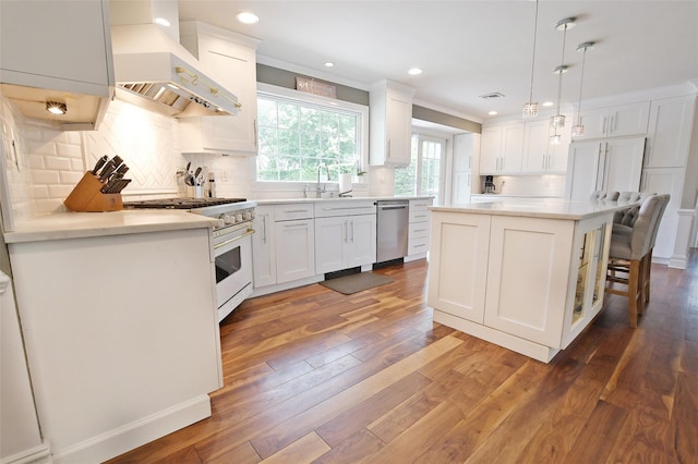 213 Glenwood Ln, Port Jefferson, NY 11777 - kitchen featuring range with gas cooktop, wall chimney exhaust hood, stainless steel dishwasher, white cabinetry, and ornamental molding