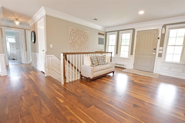 213 Glenwood Ln, Port Jefferson, NY 11777 - entryway featuring a baseboard heating unit, a decorative wall, wood finished floors, a wainscoted wall, and crown molding