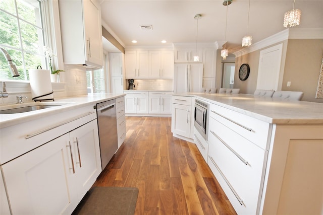 213 Glenwood Ln, Port Jefferson, NY 11777 - kitchen featuring appliances with stainless steel finishes, a sink, backsplash, white cabinetry, and light wood finished floors