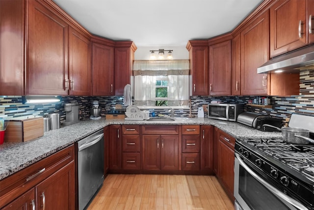 62 Buena Vista Rd, New City, NY 10956 - kitchen featuring stainless steel appliances, under cabinet range hood, a sink, light stone countertops, and decorative backsplash