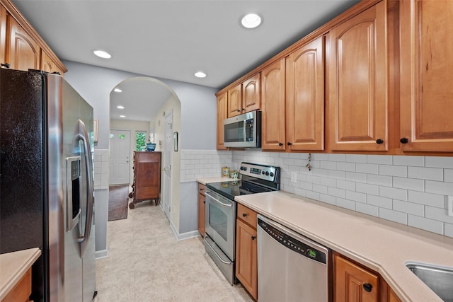 5005 John Hancock Ct Unit 100, New Windsor, NY 12553 - kitchen with appliances with stainless steel finishes, light countertops, arched walkways, recessed lighting, and backsplash