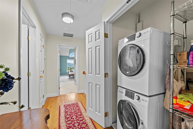 5005 John Hancock Ct Unit 100, New Windsor, NY 12553 - laundry room with estacked washer and dryer, light wood-style flooring, and baseboards