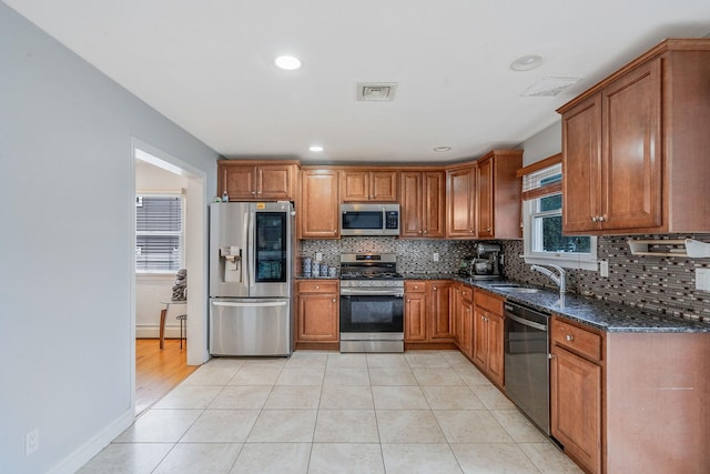 130 W 7th St, Deer Park, NY 11729 - kitchen with appliances with stainless steel finishes, a sink, brown cabinetry, a baseboard radiator, and recessed lighting