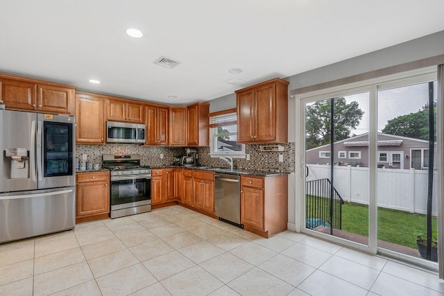 130 W 7th St, Deer Park, NY 11729 - kitchen featuring appliances with stainless steel finishes, brown cabinets, a sink, backsplash, and recessed lighting