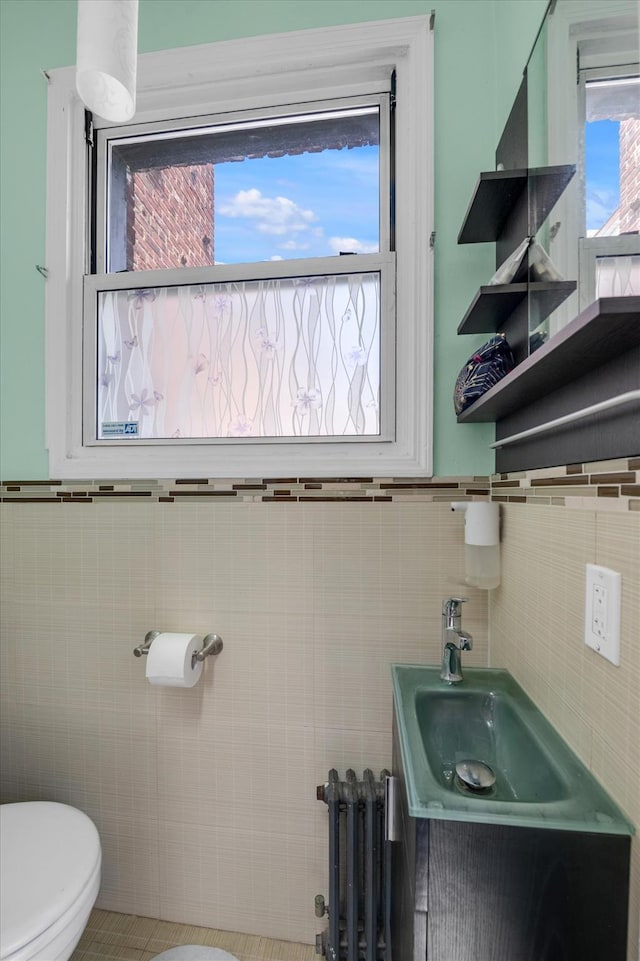 200-12 36th Ave, Bayside, NY 11361 - half bath featuring radiator heating unit, tile walls, toilet, vanity, and a wainscoted wall