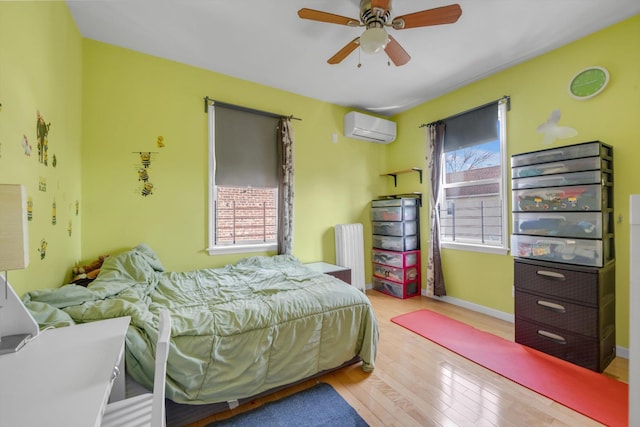 200-12 36th Ave, Bayside, NY 11361 - bedroom featuring a wall mounted AC, hardwood / wood-style floors, baseboards, ceiling fan, and radiator