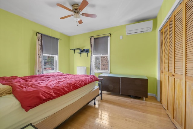 200-12 36th Ave, Bayside, NY 11361 - bedroom with a wall mounted AC, hardwood / wood-style floors, a closet, radiator, and ceiling fan