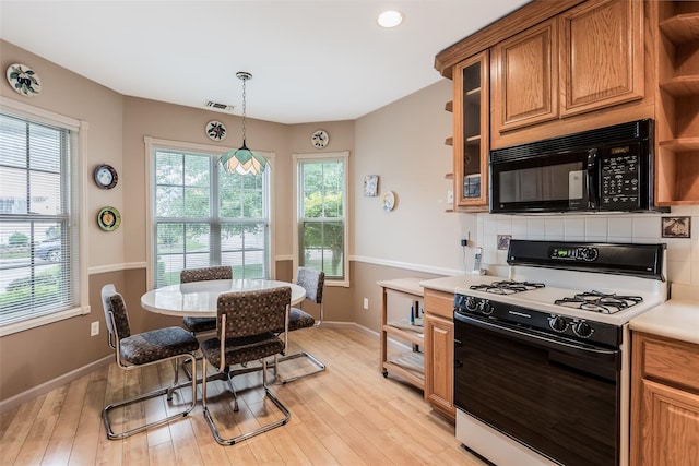 75 Madison Cir, Middle Island, NY 11953 - kitchen with gas range, black microwave, brown cabinetry, light wood-style flooring, and open shelves