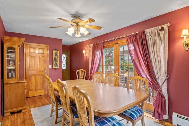 13 Evans Ave, Albertson, NY 11507 - dining area featuring a baseboard radiator, ceiling fan, and light wood-style floors