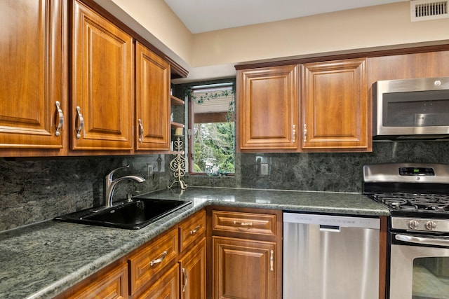 13 Evans Ave, Albertson, NY 11507 - kitchen featuring stainless steel appliances, a sink, and brown cabinetry