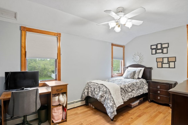 13 Evans Ave, Albertson, NY 11507 - bedroom with a baseboard heating unit, multiple windows, vaulted ceiling, light wood-type flooring, and a desk