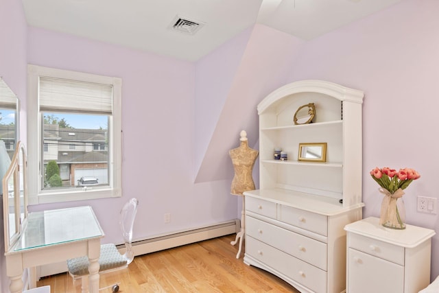 13 Evans Ave, Albertson, NY 11507 - living area with a baseboard heating unit and light wood-style flooring