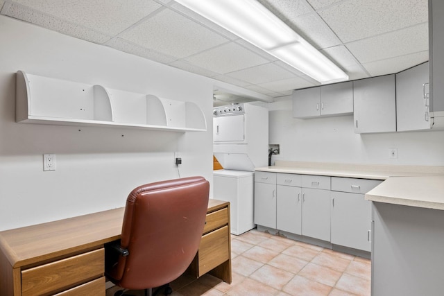 13 Evans Ave, Albertson, NY 11507 - kitchen featuring stacked washer / dryer, a paneled ceiling, light countertops, light tile patterned flooring, and open shelves