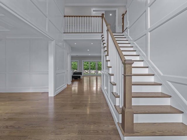 15 Grenfell Dr, Great Neck, NY 11020 - stairs featuring a decorative wall, ornamental molding, wood finished floors, and a towering ceiling