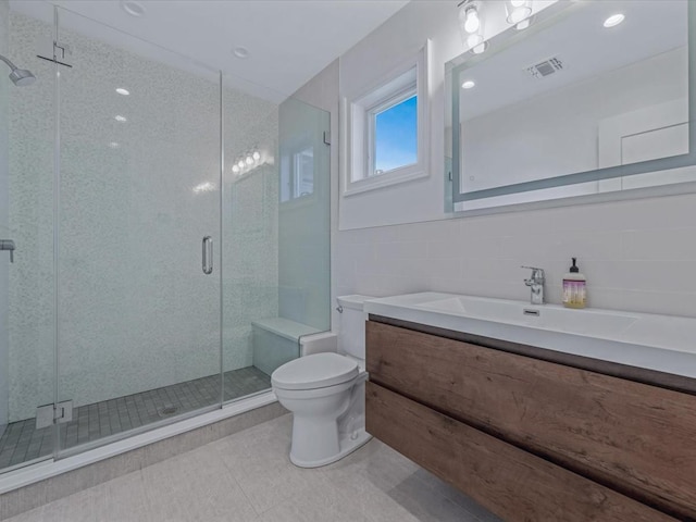 15 Grenfell Dr, Great Neck, NY 11020 - full bathroom featuring vanity, toilet, tile patterned flooring, a shower stall, and tile walls