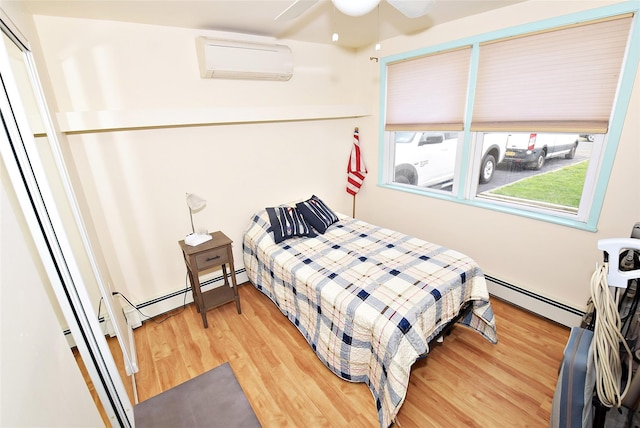 32 Shore Dr, Mastic Beach, NY 11951 - bedroom featuring a wall unit AC, baseboard heating, and light wood-style flooring