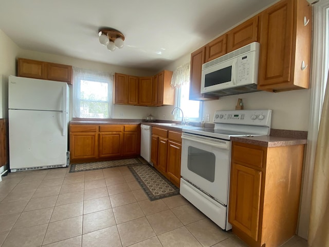 32 Shore Dr, Mastic Beach, NY 11951 - kitchen with white appliances, brown cabinetry, dark countertops, a sink, and light tile patterned flooring
