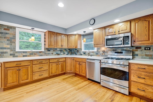 40 Pine St, New City, NY 10956 - kitchen with appliances with stainless steel finishes, light wood finished floors, hanging light fixtures, backsplash, and recessed lighting