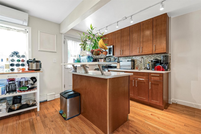 110-25 64th Rd Unit 10, Forest Hills, NY 11375 - kitchen featuring rail lighting, stainless steel microwave, light countertops, light wood-style flooring, and backsplash