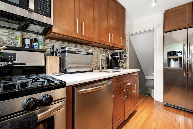 110-25 64th Rd Unit 10, Forest Hills, NY 11375 - kitchen featuring appliances with stainless steel finishes, a sink, light countertops, light wood-style floors, and backsplash