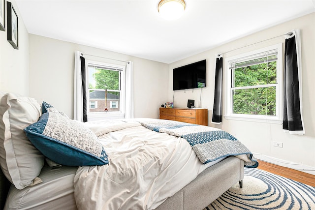 110-25 64th Rd Unit 10, Forest Hills, NY 11375 - bedroom with wood finished floors, multiple windows, and baseboards