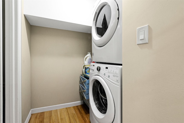 110-25 64th Rd Unit 10, Forest Hills, NY 11375 - washroom featuring stacked washer / dryer, wood finished floors, and baseboards
